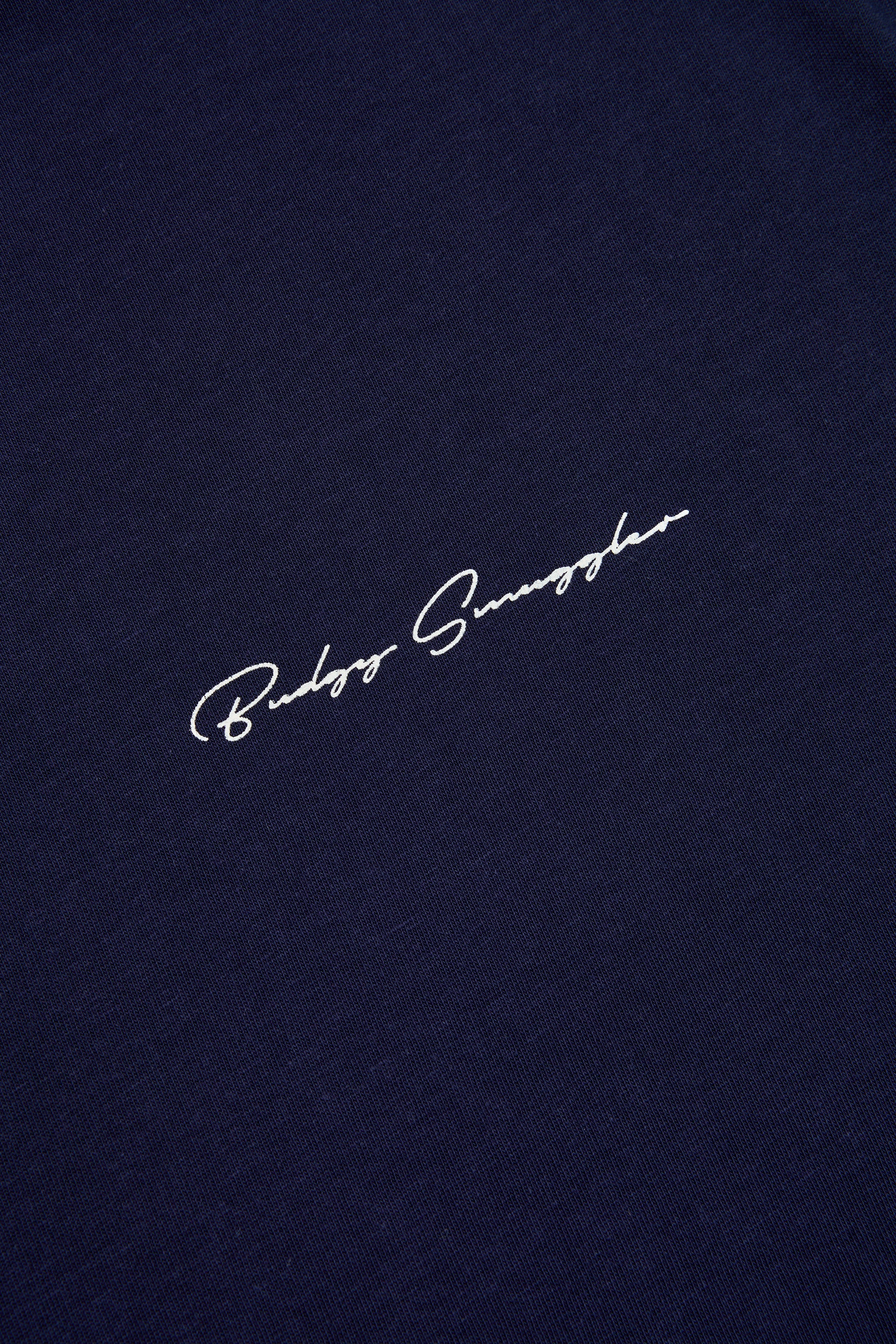 Close up of the white Budgy Smuggler script on the navy tee